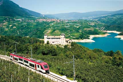 Cles, Castel Cles. In primo piano la ferrovia Trento-Malè. Sullo sfondo il paese di Revò