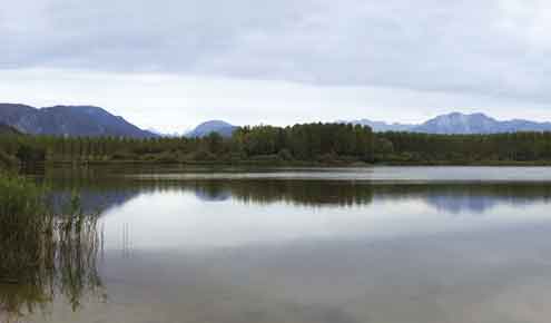 Il lago visto dalla "spiaggetta", sullo sfondo le Prealpi Carniche e Giulie